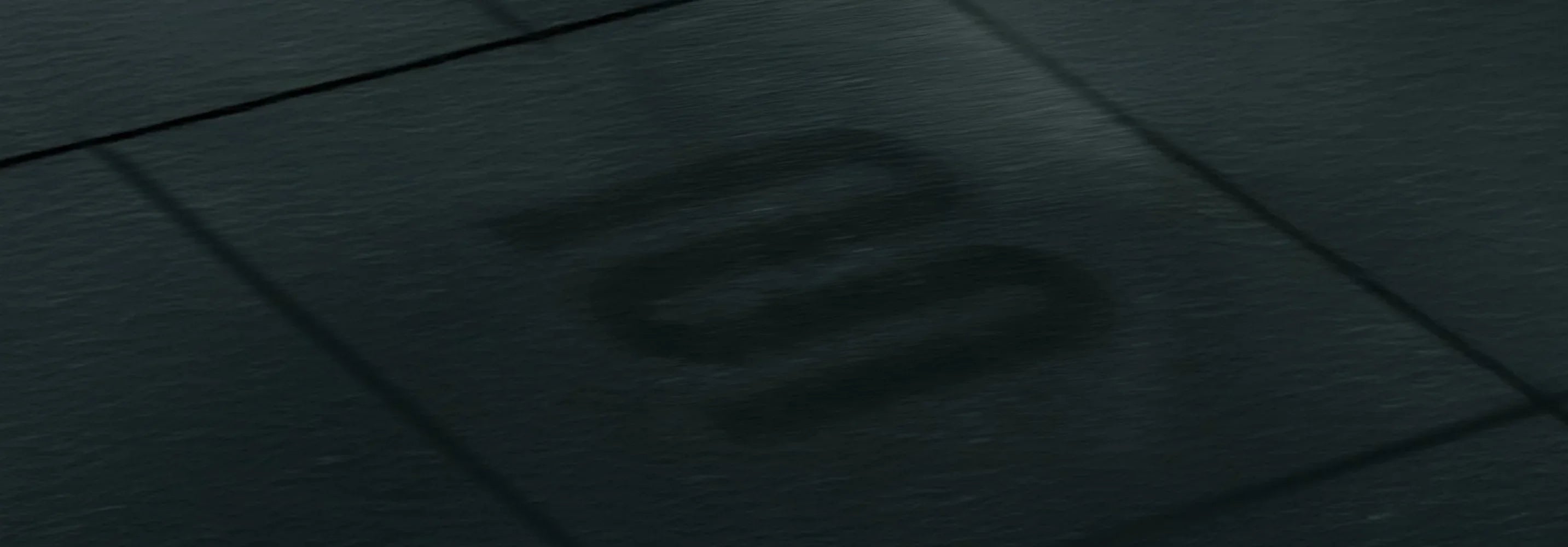 Close-up of a textured black surface with a logo