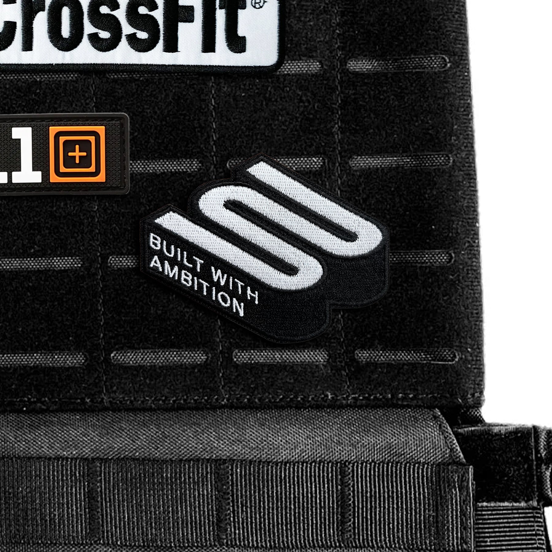 Black tactical vest with CrossFit and embroidered athlete patches, text 'Built With Ambition'