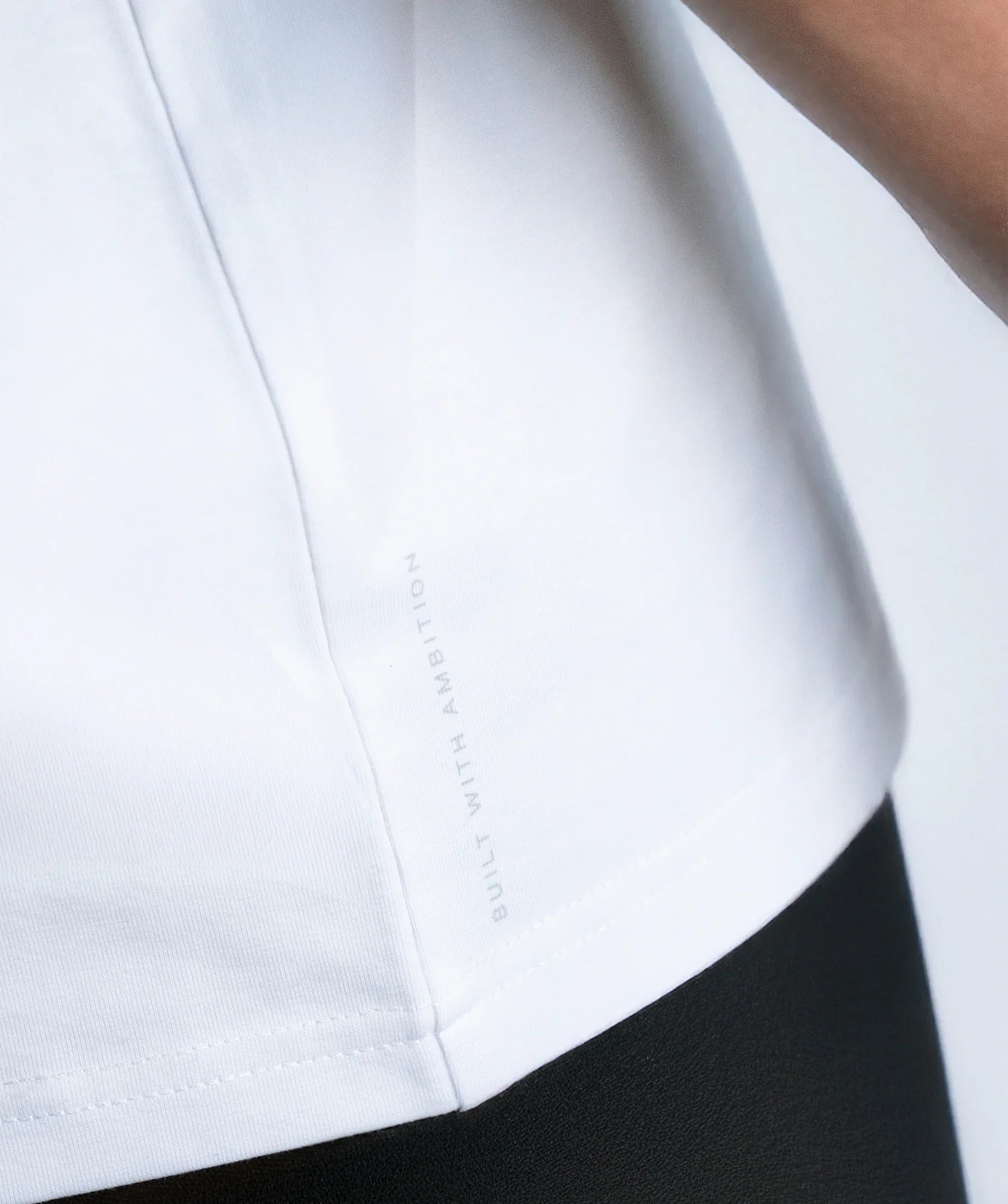 Close-up of a white shirt with a brand logo on the collar.