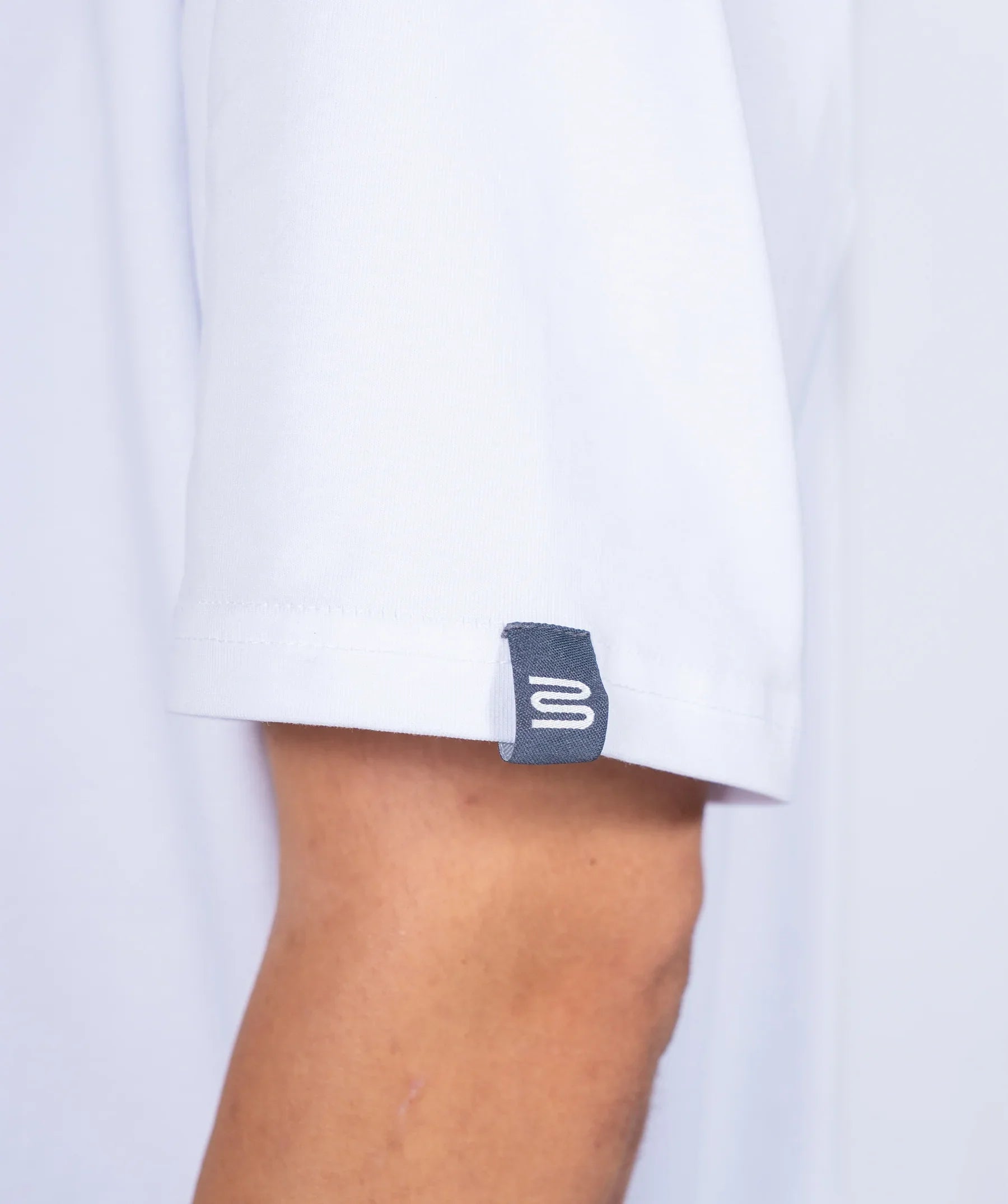 Close-up of a white 'Centric' t-shirt with a brand label on a white background