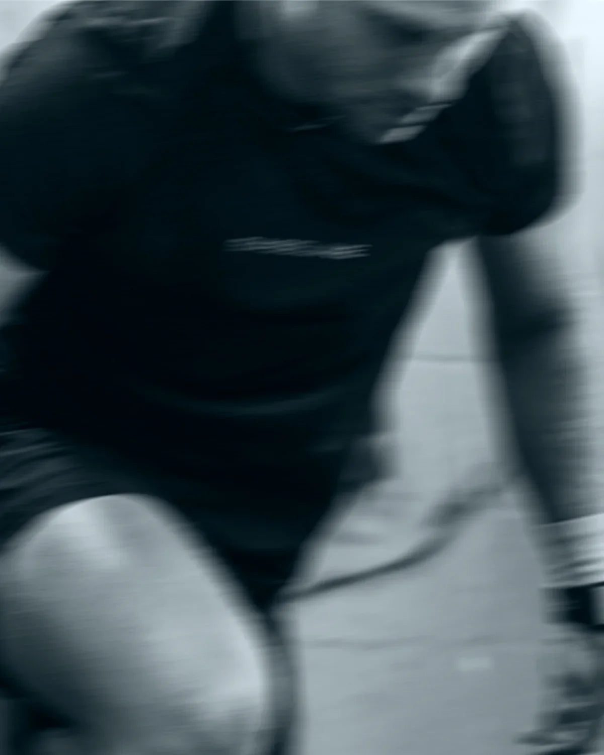 Person wearing a black shirt with a logo on a blurred background