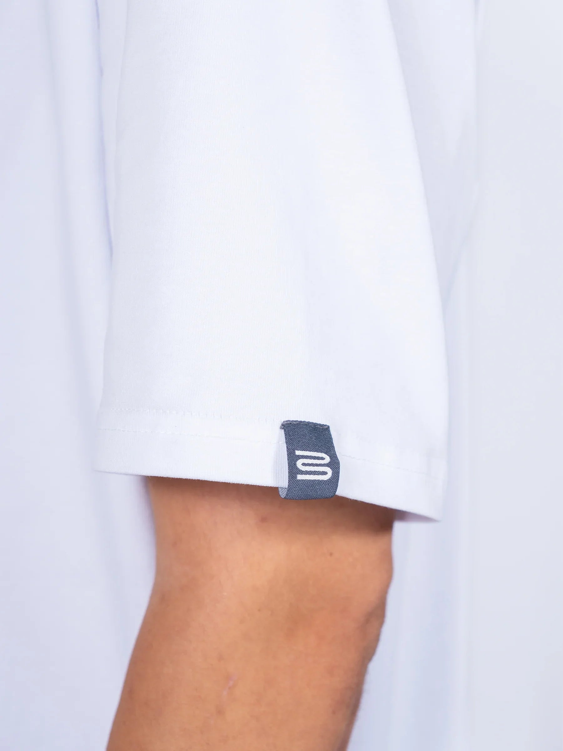 Close-up of a white 'Centric Oversized' shirt cuff with a brand label on a light gray background