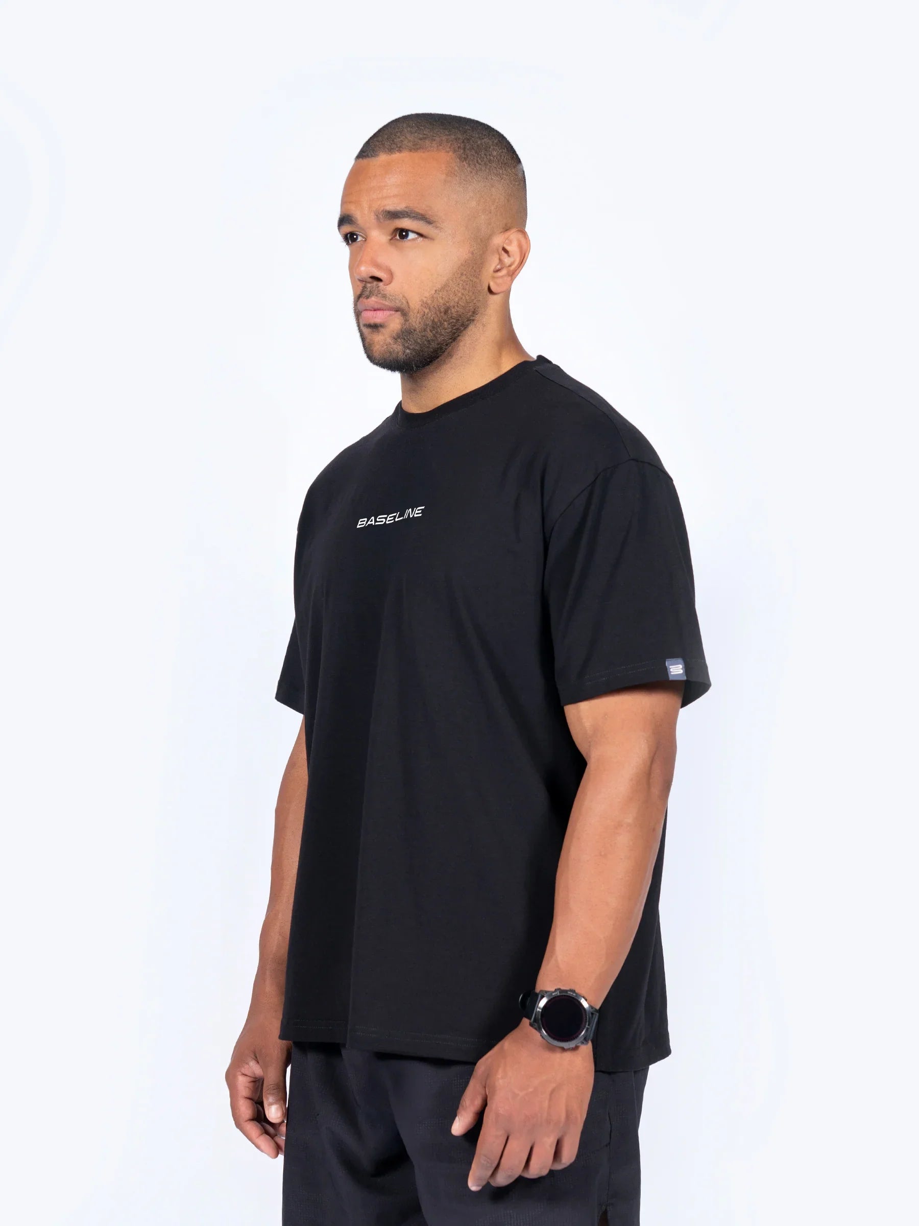 Male athlete wearing a black 'Icon Oversized' t-shirt with a brand logo on a white background