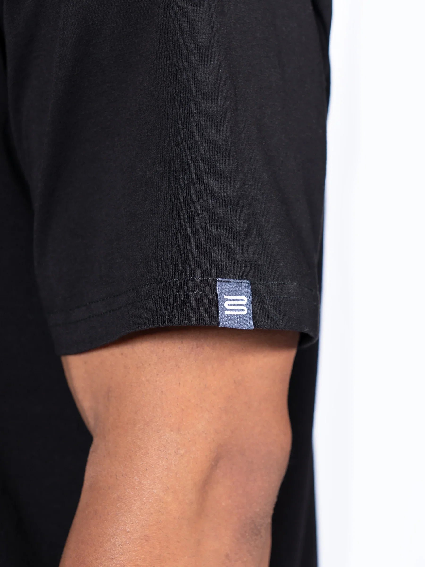 Black 'Icon Oversized' t-shirt with a small logo on the sleeve against a white background