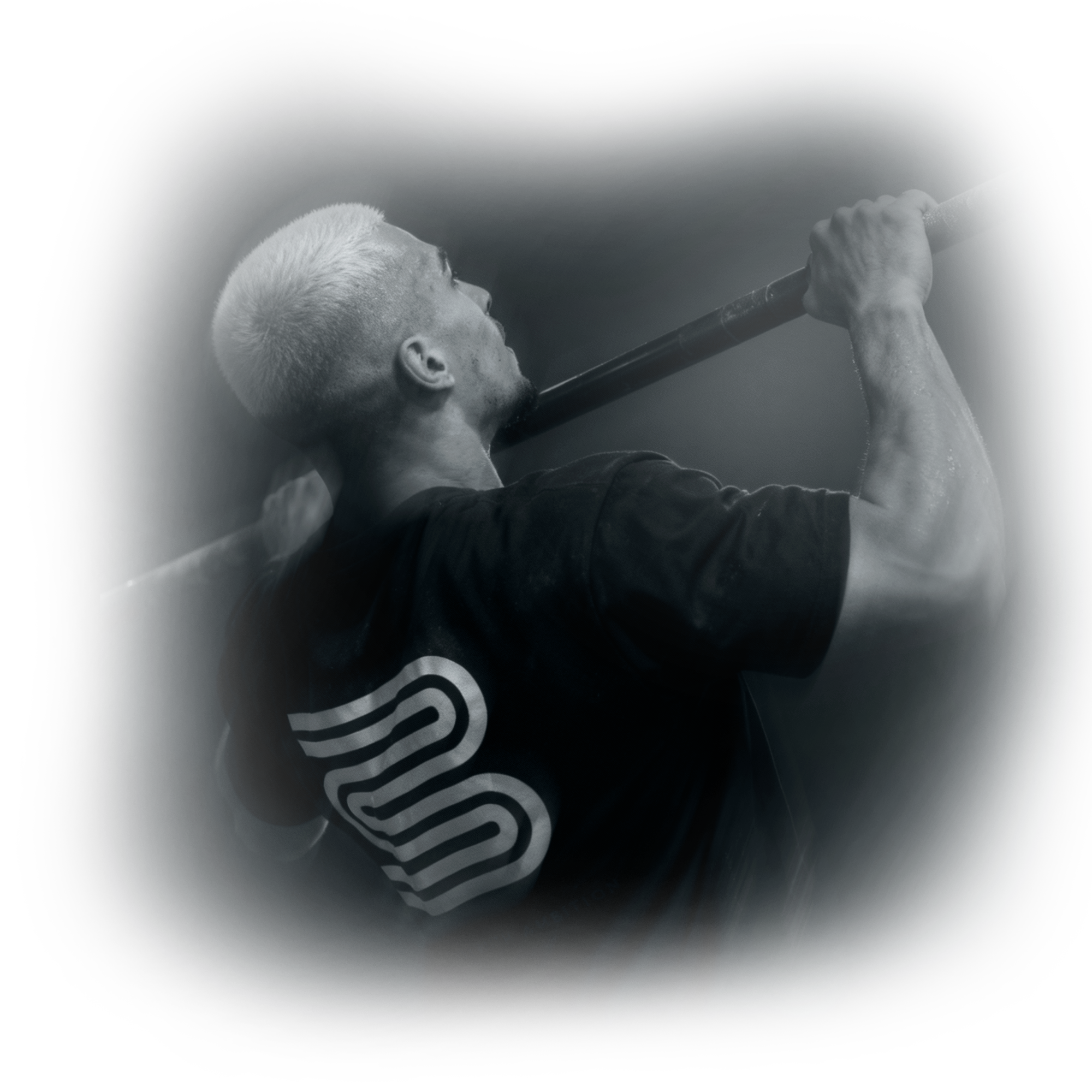 Black and white image of a person doing a pull-up with a logo on their shirt.